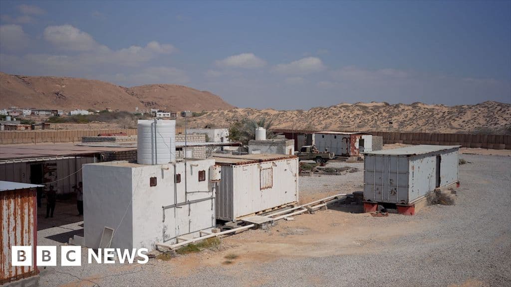 A stark contrast split image: on one side, the glittering, futuristic skyline of Dubai with fireworks; on the other side, a dusty, desolate, rusty shipping container in the desert of Yemen under a harsh sun, photorealistic style.
