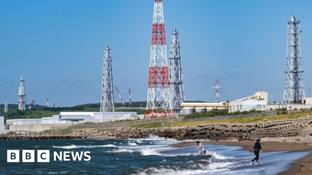 A highly stylized, cynical editorial illustration of a massive, sleek nuclear power plant sitting precariously on a giant, cracked puzzle piece of land, surrounded by dark, churning ocean waves. In the foreground, a group of tiny, identical bureaucrats in grey suits are bowing deeply toward the plant, holding oversized clipboards. The sky is an eerie, ironic neon green, casting a radioactive glow over the scene. The style is sharp, sophisticated, and minimalist, reminiscent of a high-end European political magazine.