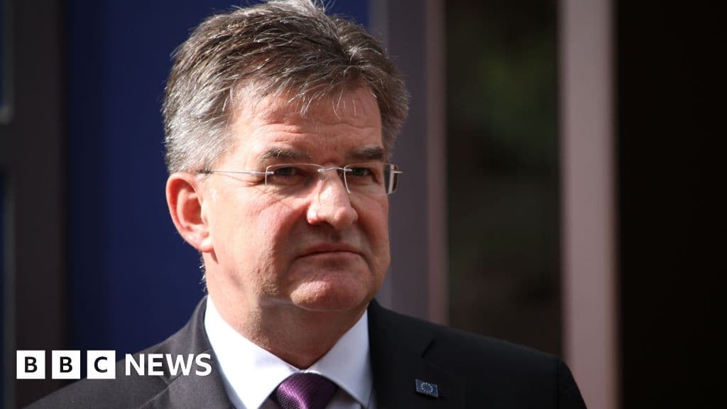 A hyper-realistic, cynical editorial illustration showing a sleek, modern government office desk in Slovakia. On the desk, a pristine nameplate reads 'NATIONAL SECURITY ADVISER'. Next to it is a shredder overflowing with paper, and a smartphone displaying a 'message deleted' notification. The lighting is cold and blue, emphasizing a sterile, corporate atmosphere. No people are visible, just the remnants of a hasty departure.