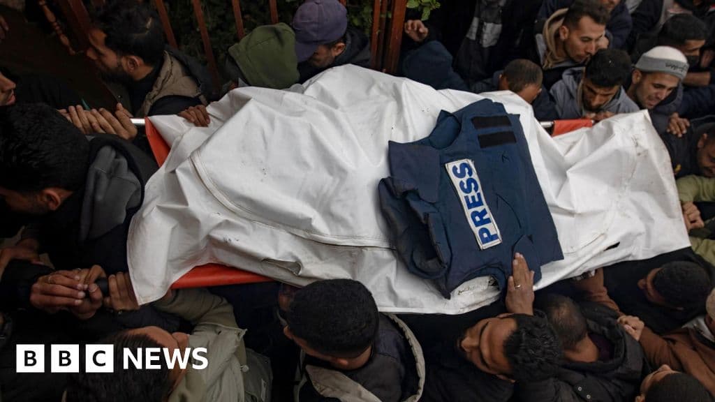 A hyper-realistic, gritty image of a dirty, torn blue press vest lying abandoned in a pile of gray concrete rubble and dust. In the background, a blurred, desolate cityscape of Gaza with smoke rising. The lighting is harsh and desaturated, emphasizing the texture of the debris and the futility of the protective gear. No people visible, just the discarded symbol of the press.