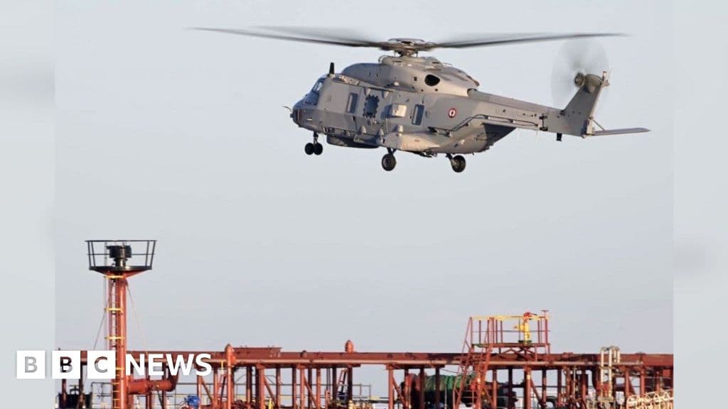 A large, weathered, rust-streaked oil tanker named 'Grinch' being intercepted by a sleek, modern French naval frigate in the sun-drenched Mediterranean Sea between the Spanish and Moroccan coasts. The scene is captured with a cynical, cinematic filter, highlighting the contrast between the decaying merchant ship and the polished military vessel. Cinematic lighting, deep blue water, 8k resolution.