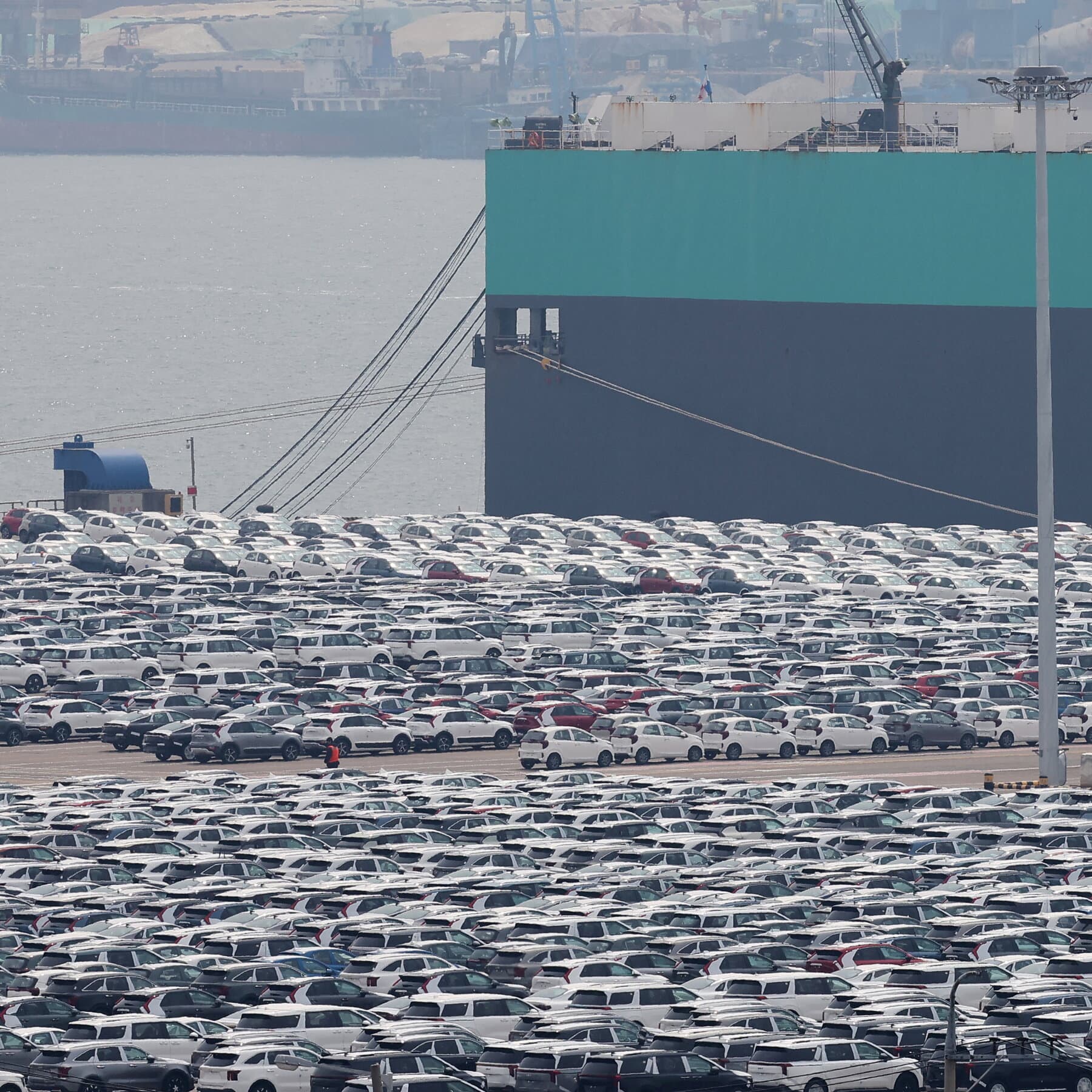 A hyper-realistic, cynical editorial illustration showing a Canadian flag and a South Korean flag tied together with a flimsy piece of string, stretching across a vast, dark ocean. In the background, a massive, looming shadow of the American map is cast over the scene. The atmosphere is cold, bureaucratic, and slightly absurd. Muted colors, grey and dark blue tones.