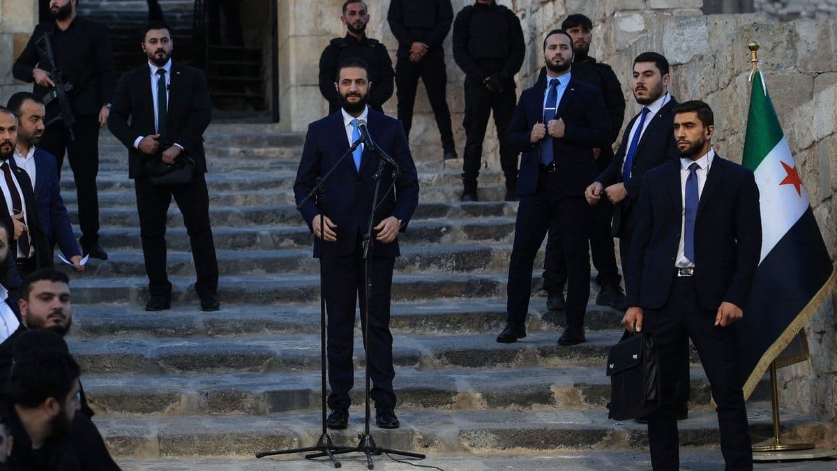 A hyper-realistic, cynical digital painting of a man in a sharp, expensive business suit sitting in an ornate White House chair, but his shadow on the wall behind him is the silhouette of a masked insurgent holding a rifle. The lighting is cold and clinical, highlighting the hypocrisy of the setting. The background shows a blurred, chaotic Damascus skyline transitioning into the pristine White House interior.