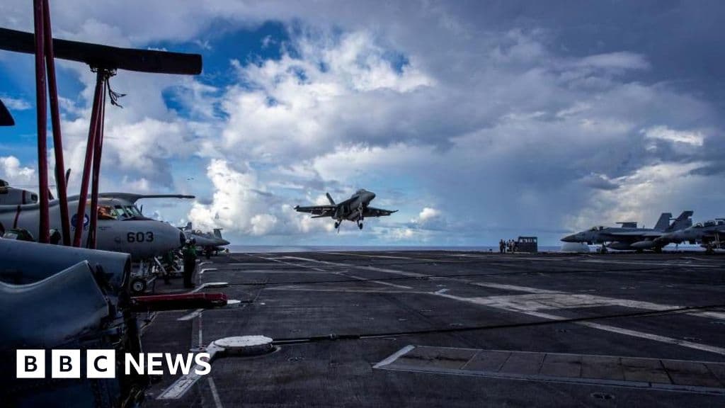 A high-contrast, grainy black and white satellite surveillance style image showing a fleet of modern warships in a formation on dark ocean water, with digital crosshairs and data overlays, minimalist and ominous.