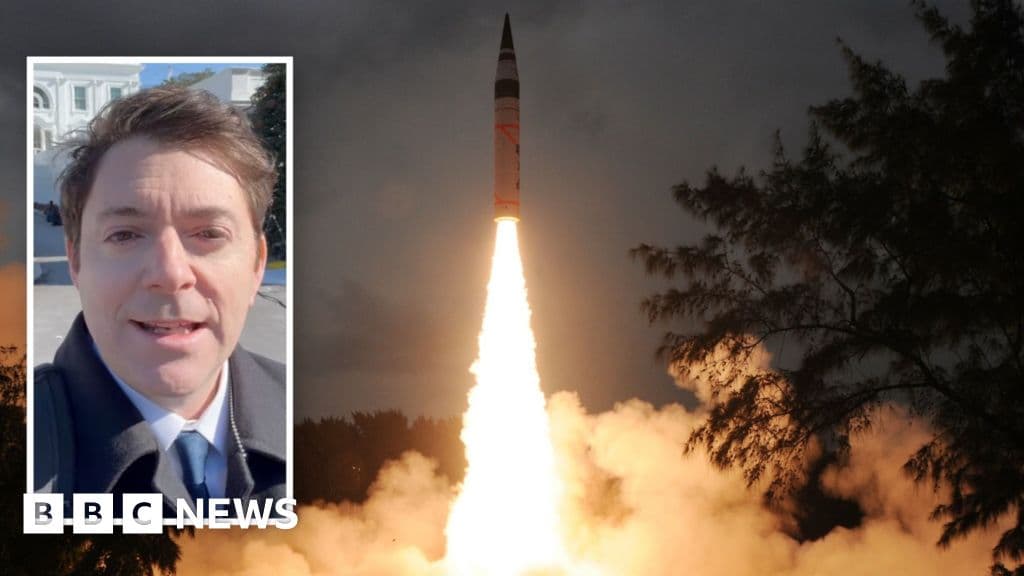 A gritty, high-contrast black and white illustration of a shredded paper treaty on a table, with a nuclear cooling tower in the background, stylized like a political cartoon.