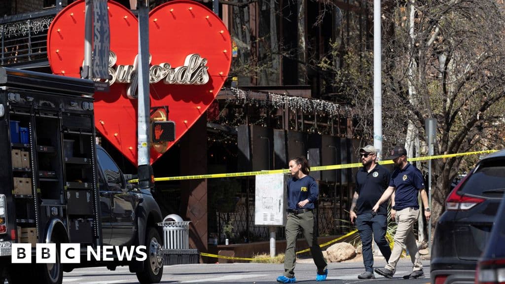 A hyper-realistic, dark, and moody image of a generic bar exterior at night, illuminated only by the flashing red and blue lights of police cruisers. Yellow crime scene tape is stretched across the foreground, fluttering in the wind. In the background, blurred silhouettes of law enforcement officials in jackets labeled 'FBI' are standing near the entrance. The ground is wet, reflecting the chaotic lights. No gore, just a heavy atmosphere of aftermath and bureaucratic coldness.