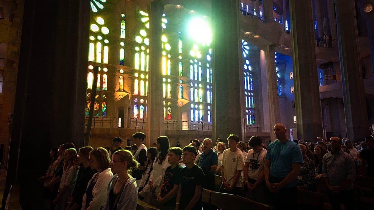 A wide, cinematic shot of a massive, ancient European cathedral. The interior is decaying, with sunlight streaming through broken stained glass. In the center, instead of pews or an altar, there is a giant, glowing blue smartphone screen standing upright, illuminating a crowd of people who are all looking down at their own handheld phones, ignoring the architecture around them. The style is dark, satirical, and hyper-realistic.