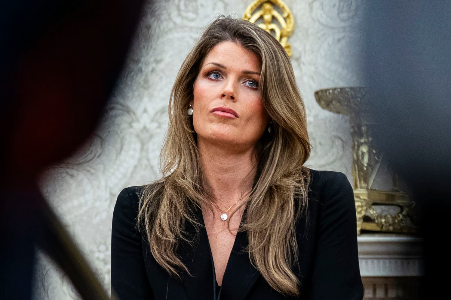 A satirical oil painting of a courtroom where a judge is handing a gold-plated 'Get Out of Jail Free' card to a lawyer wearing a toddler's oversized suit and a bib. In the background, a massive statue of James Comey is smirking. The atmosphere is dark, cynical, and cluttered with legal scrolls that are actually blank.