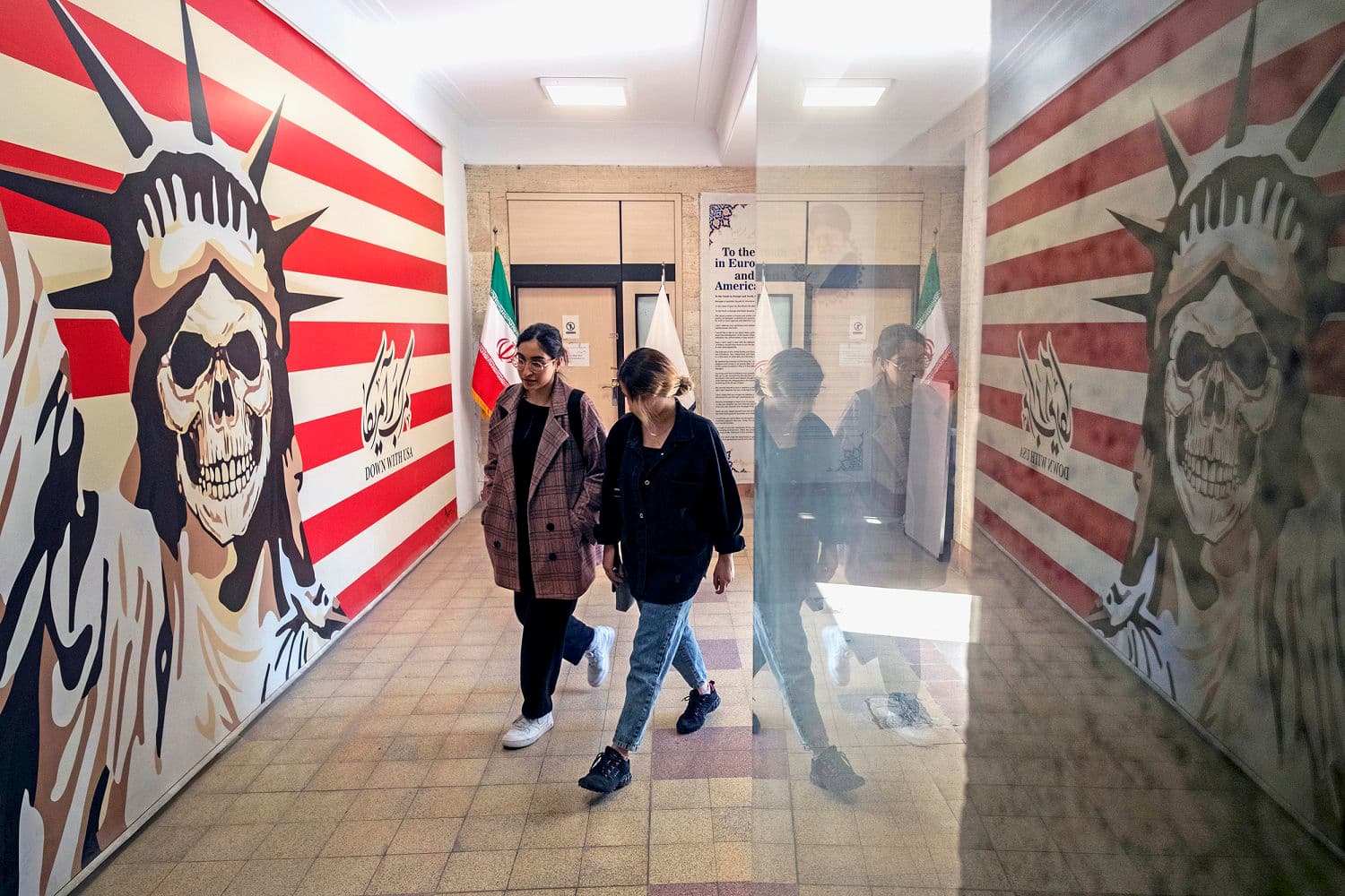 A gritty, noir-style illustration of a departure gate at an airport. In the foreground, a tired looking man in a rumpled suit drags a suitcase. In the background, looming large and shadowy, are faceless politicians in suits playing with toy soldiers. The color palette is dark blues and greys with a single bright red warning light.