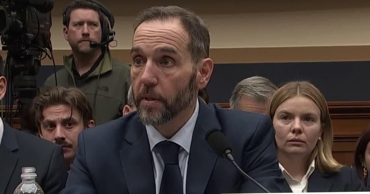 A hyper-realistic, dark satirical digital painting of a courtroom where the judge’s bench is a literal circus podium. In the center, a man resembling Jack Smith stands defiantly in a grey suit, while a golden crown hovers ominously over a prosecutor's desk labeled 'Retribution'. The lighting is moody and cynical, like a film noir directed by a nihilist, with spectators in the background wearing both red and blue blindfolds.