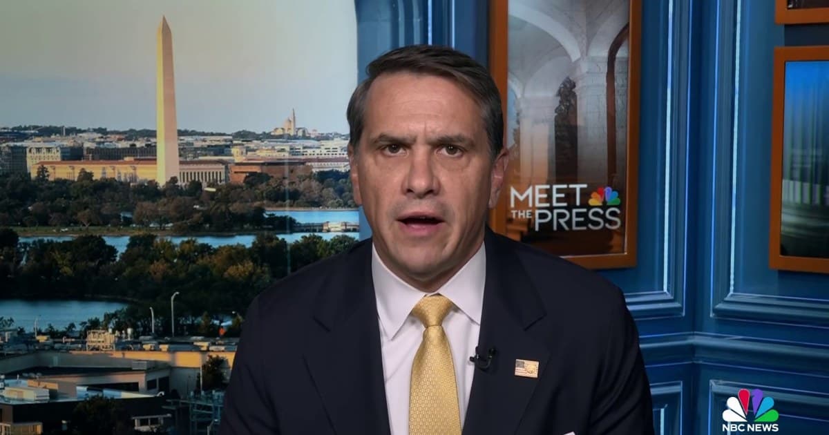 A hyper-realistic, cynical illustration of a television interview set. A polished man in a suit sits comfortably under bright studio lights, smiling slightly. Behind him, instead of a studio backdrop, is a chaotic, shadowy scene of a Minneapolis street with crime scene tape, creating a stark and ironic contrast between the sterile interview and the gritty reality. The style should be moody and slightly surreal.