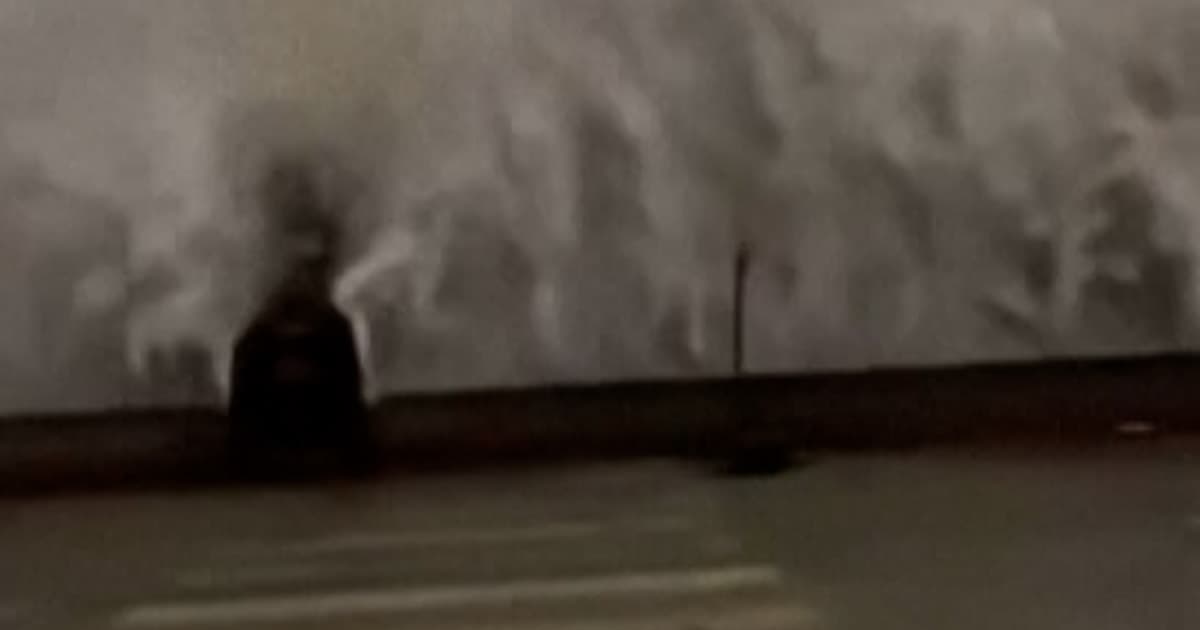 A sophisticated satirical oil painting in a dramatic Baroque style, depicting an Italian mayor in a dark suit being swept off his feet by a massive, crashing ocean wave on a rocky Sicilian shore, high-visibility vests floating in the water, golden hour light, cinematic and ironic.