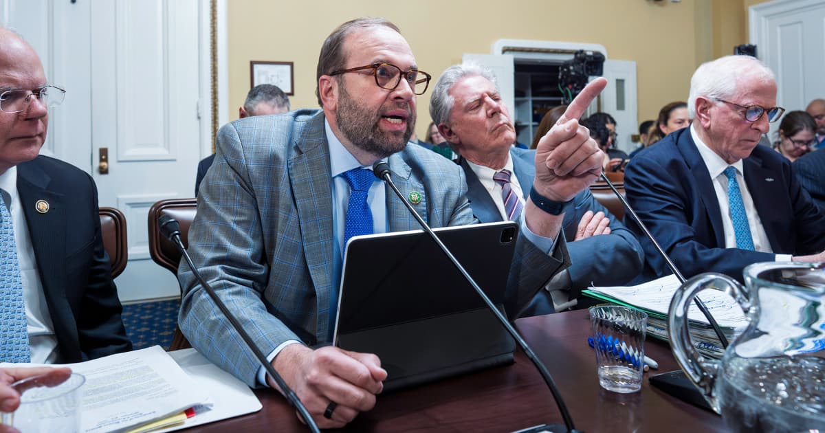 A wide-angle satirical illustration inside a dimly lit US Congress hearing room. In the foreground, five large, anthropomorphic cash registers wearing expensive tailored suits sit at a witness table. Facing them are politicians depicted as clowns and circus performers, waving wooden gavels. The background features a gallery of skeletons clapping. The atmosphere is smoky and cynical, hyper-realistic political cartoon style.