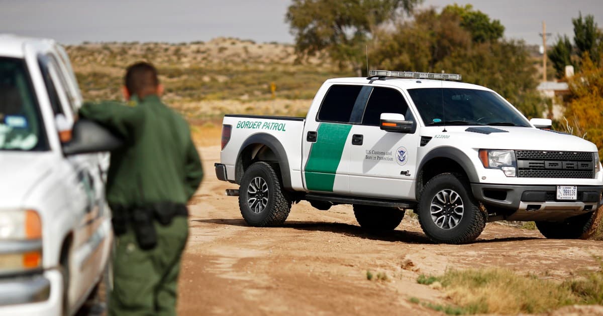 A gritty, realistic style digital art piece depicting a high-tech military laser vehicle in the Texas desert aiming a beam of light at a generic surveillance drone in the sky. The drone is smoking and falling. The background is a dusty, barren landscape under a harsh sun. The tone should be cynical and bleak.
