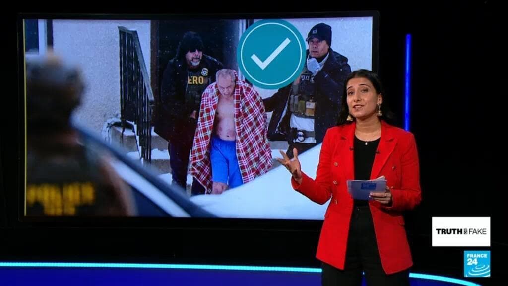 A gritty, satirical oil painting of a crowd of faceless people in a dark American city, all holding glowing smartphones up to film a blurry, static-filled scene of an arrest. The ICE agents are depicted as grey, robotic figures with no eyes, and the person being arrested is a fading silhouette. In the background, a large billboard displays the words 'TRUTH OR FAKE' in neon letters, dripping with black ink. The atmosphere is oppressive, cynical, and hyper-modern.