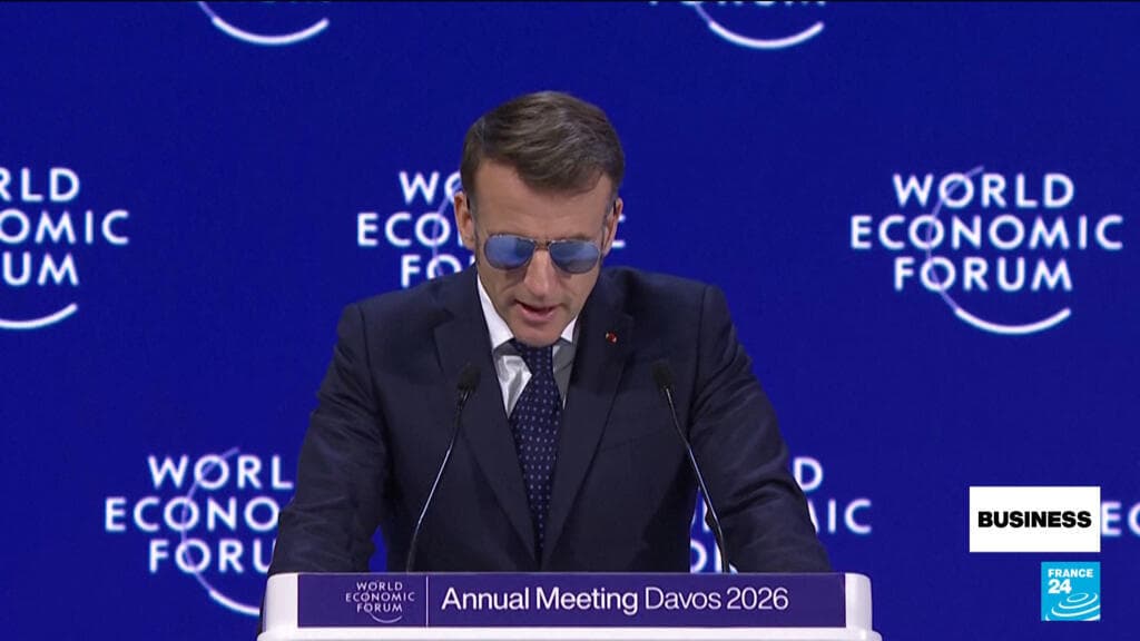 A satirical digital painting of Emmanuel Macron standing on a podium at Davos, holding a comically oversized bazooka made of rolled-up European Union treaties and red tape, while across the Atlantic, a giant Donald Trump sits on a throne of shipping containers, eating a gold-plated tariff document like a hamburger.