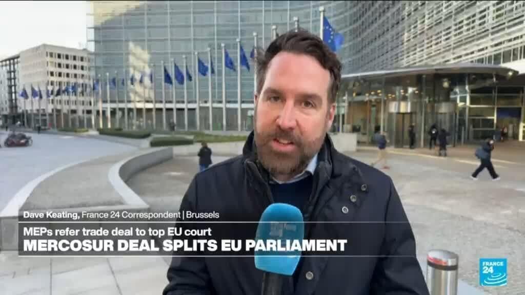 A surreal, wide-angle shot of a massive, dusty European courtroom where the judges are giant snails wearing powdered wigs. In the center, a mountain of yellowing trade documents is being slowly covered by cobwebs. Outside the window, a group of angry French farmers are throwing baguettes at a golden statue of Ursula von der Leyen. The lighting is cold, bureaucratic grey, emphasizing a sense of eternal stagnation.