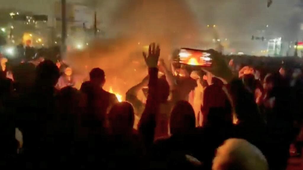 A hyper-realistic, cynical digital art piece showing a massive, rusted iron lever labeled 'SOVEREIGNTY' being pulled down by a withered, clerical hand. The lever is crushing a bundle of glowing, neon-blue fiber-optic cables that are bleeding dark, binary-code fluid onto a cracked desert floor. In the background, a silhouette of a city is fading into a thick, grey fog of static, with one lonely, unpowered cell tower standing like a tombstone.