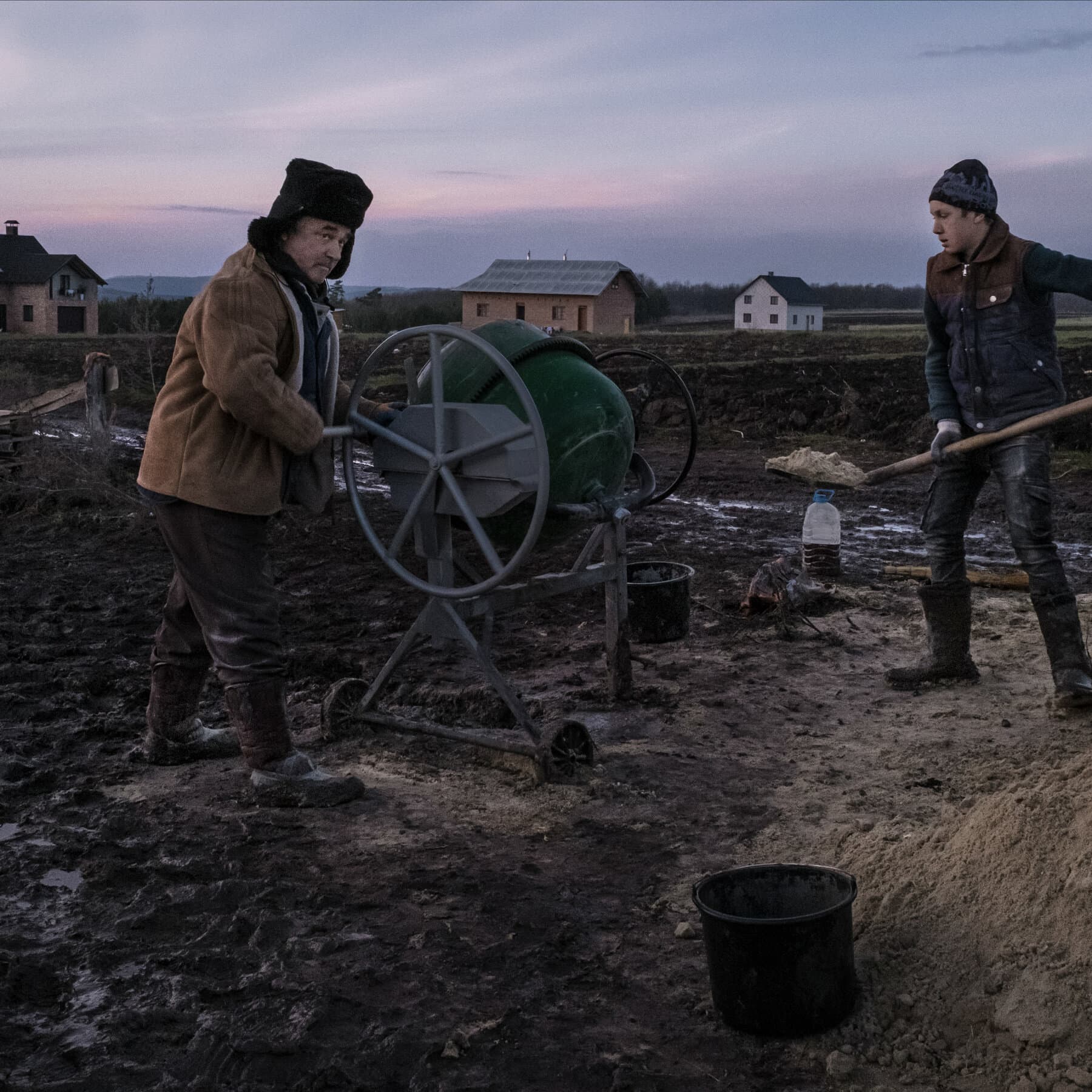 A moody oil painting of a rustic wooden house in a Ukrainian field at dusk. The windows are dark with no light coming from inside. In the background, storm clouds gather over a vast, empty landscape. No power lines, no cars, just mud and wood. The style should be gloomy and realistic.
