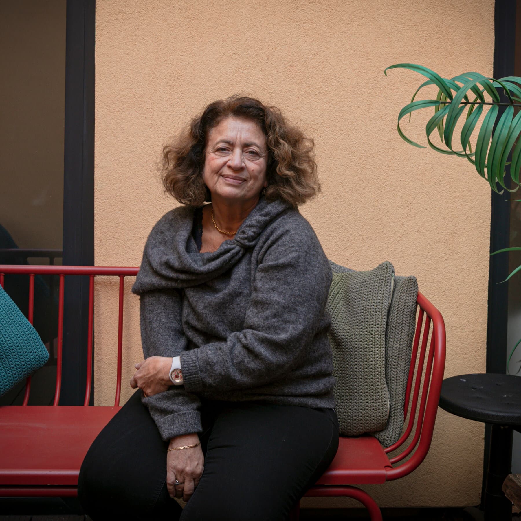 A satirical editorial illustration in the style of a sophisticated European magazine. A neoclassical French building with 'Maison des Femmes' written in elegant script, but the building is shaped like a giant, stylized first-aid kit. Outside, a line of statuesque women in chic but torn clothing wait in a perfectly orderly line, while a doctor in a white coat holds a clipboard and a magnifying glass over a map of France. The sky is a cynical, dusty grey.