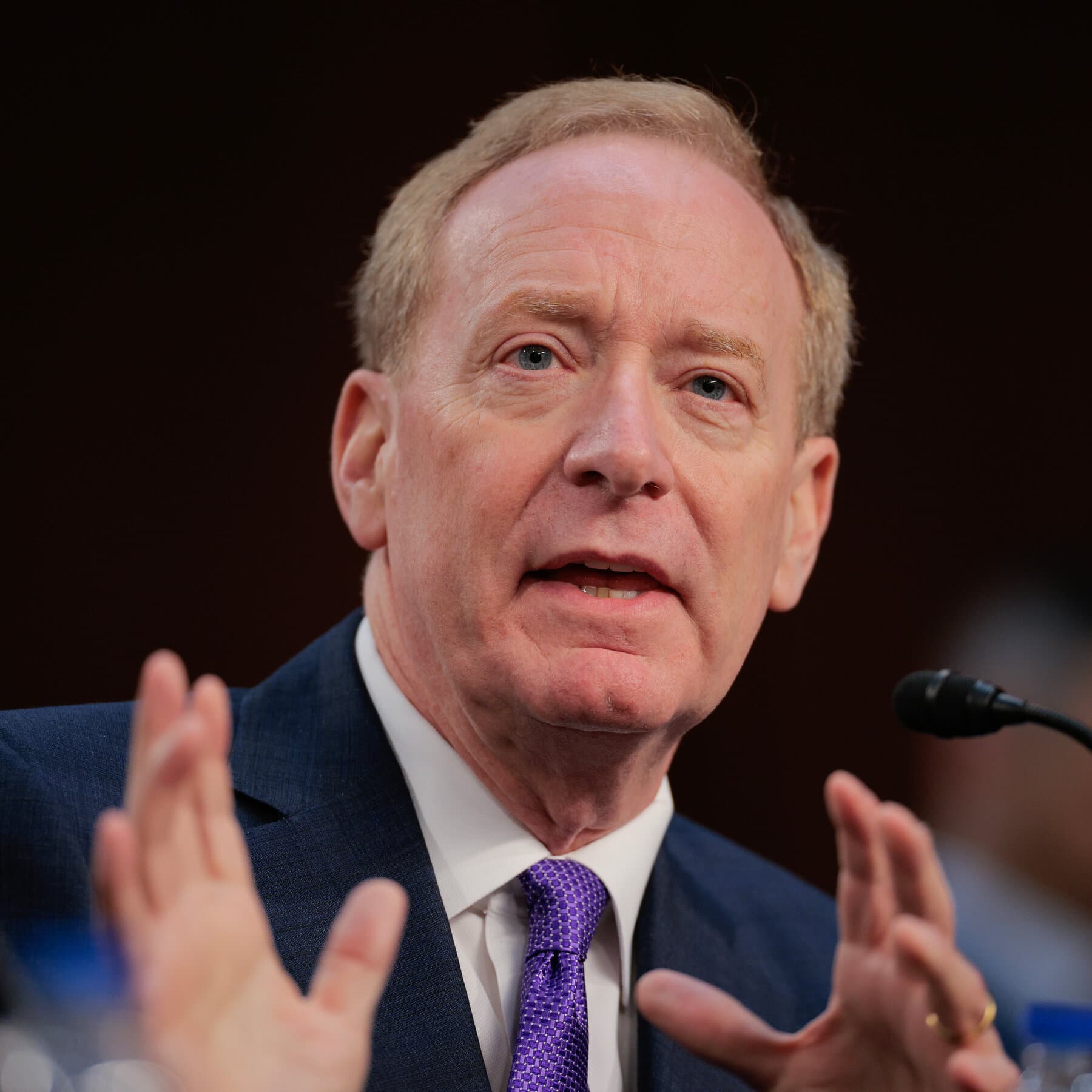 A hyper-realistic, desaturated oil painting style image. In the foreground, a sleek, ominous black server tower monolith stands in a barren field. It is glowing with harsh neon blue light. Thick, tangled power cables snake out from the monolith, latching onto a crumbling, small wooden house in the background. The house is dark and dilapidated. A single golden coin is rolling down one of the cables toward the house. The sky is a bruised purple and grey, heavy with pollution.