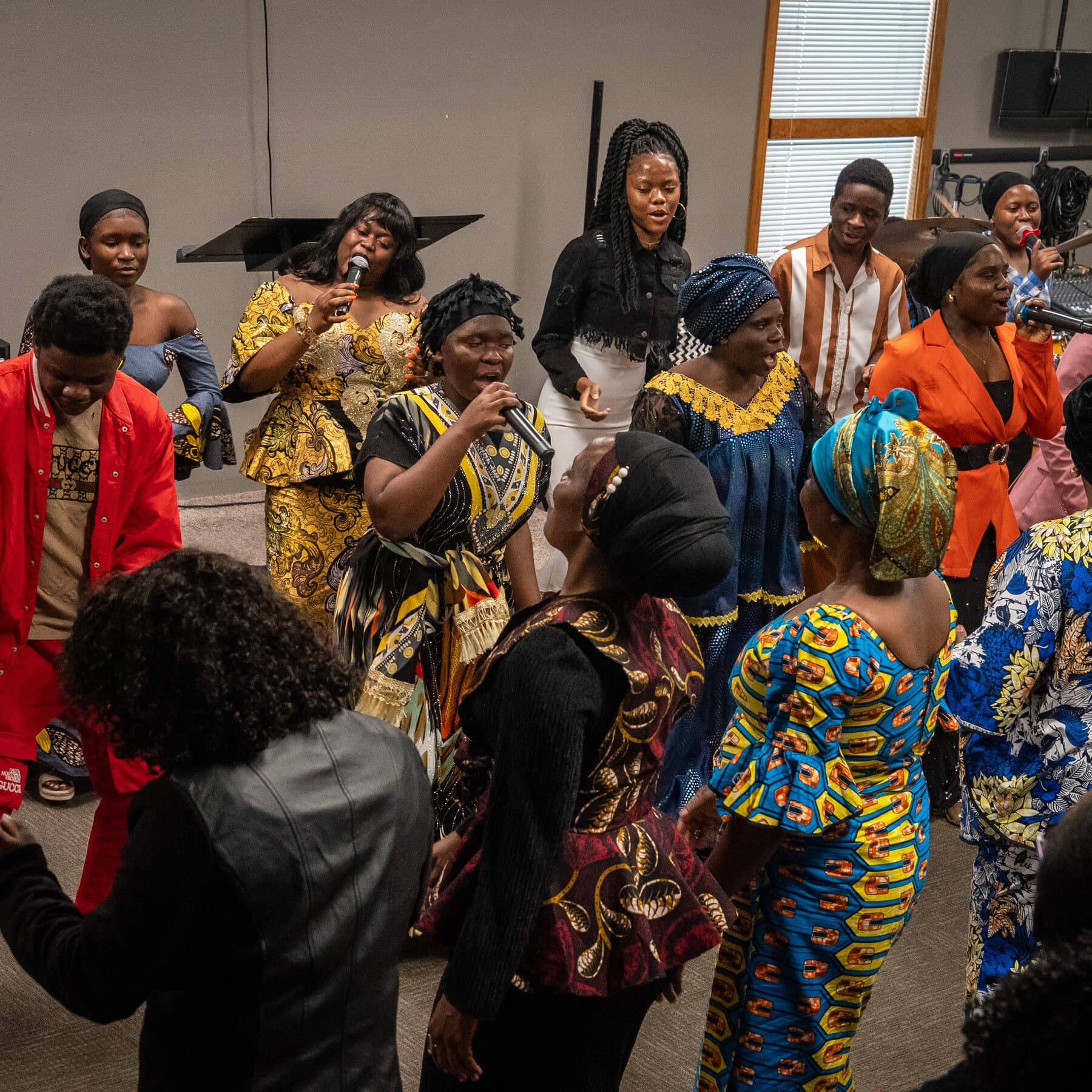 A satirical illustration in a gritty, high-contrast political cartoon style. In the foreground, a group of rugged, stern-looking Afrikaner farmers in khaki clothes are standing in a bleak American cornfield, looking confused. They are being greeted by an overweight American bureaucrat wearing a 'Make America Great Again' hat, who is holding a tray of Wonder Bread and generic American cheese. In the background, sad-looking cows watch the scene. The sky is a depressing grey.