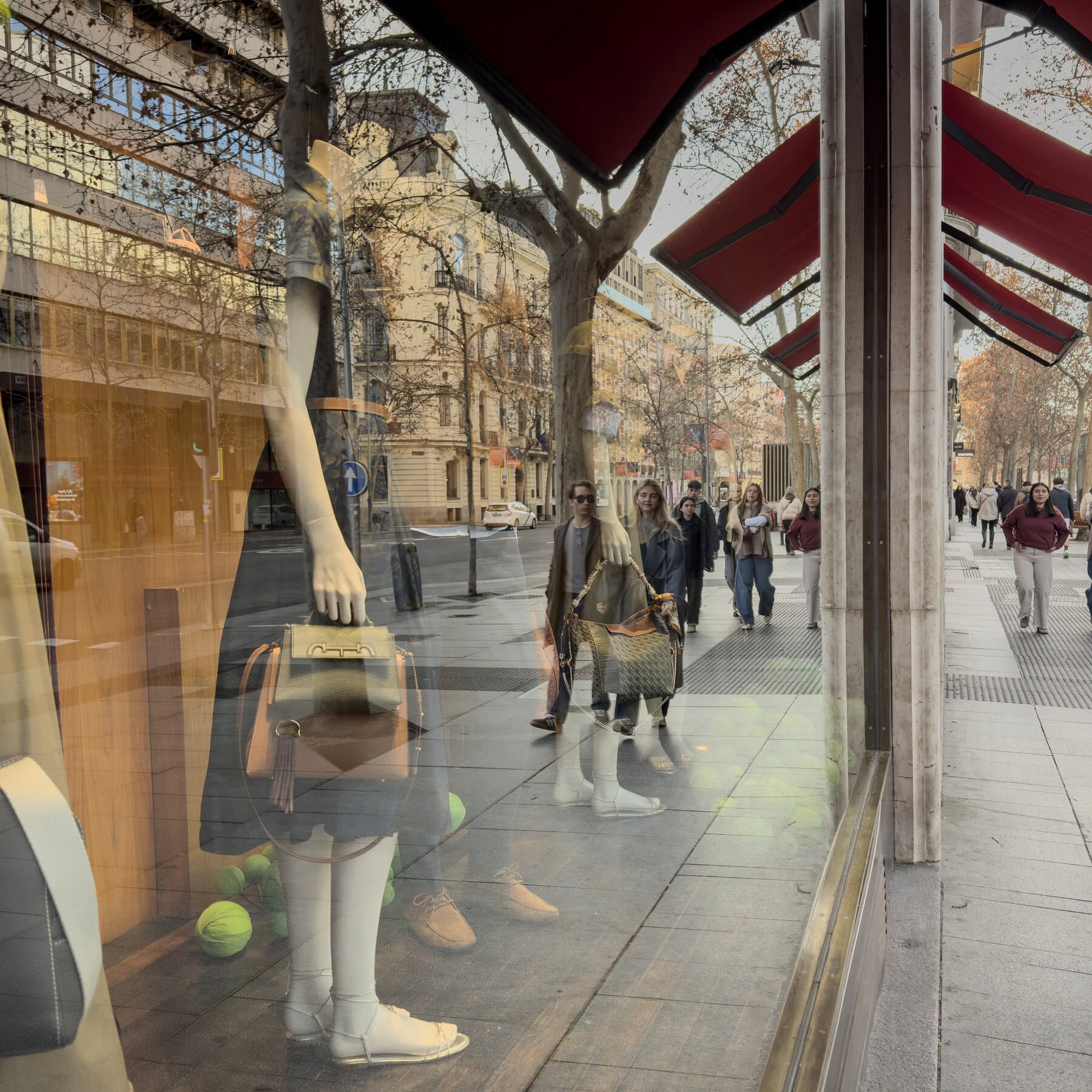 A photo of a Venezuelan man in Madrid wearing a Venezuelan flag like a cape and holding a celebratory glass of champagne in one hand, while grimly signing a thick document labeled '24-MONTH LEASE EXTENSION' with the other hand. In the background, a TV screen shows breaking news of Maduro's capture.