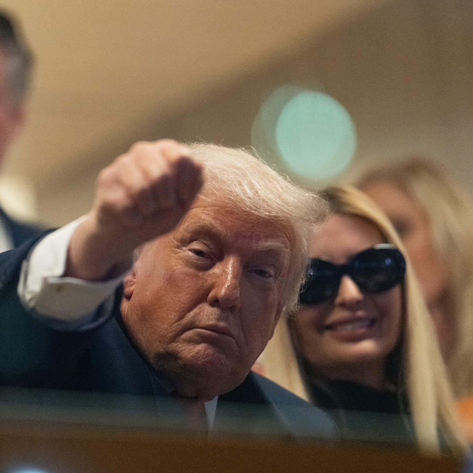 A cynical oil painting of a gold-leafed desk with a single, lonely, official-looking document on it, surrounded by screaming headlines on television screens and a background of grey, industrial smoke, in the style of Edward Hopper meets Ralph Steadman.
