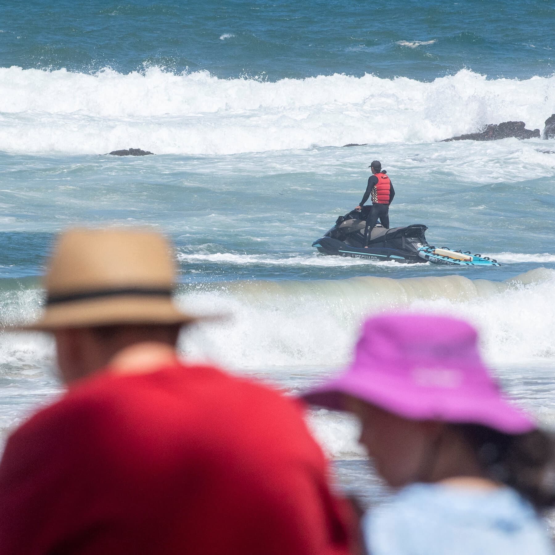 A photo of an angry Australian surfer yelling at a 'BEACH CLOSED' sign, while in the background, a massive shark is clearly jumping out of the water eating a lifeguard tower.