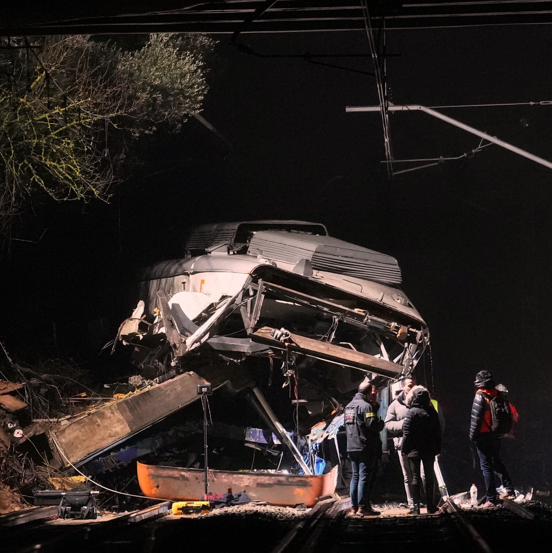 A cynical, dark-toned cinematic shot of a derailed train in a Mediterranean landscape, the metal twisted and rusted, surrounded by yellow police tape and bureaucrats in expensive suits holding clipboards while ignoring the wreckage, gloomy lighting, hyper-realistic, satirical atmosphere.