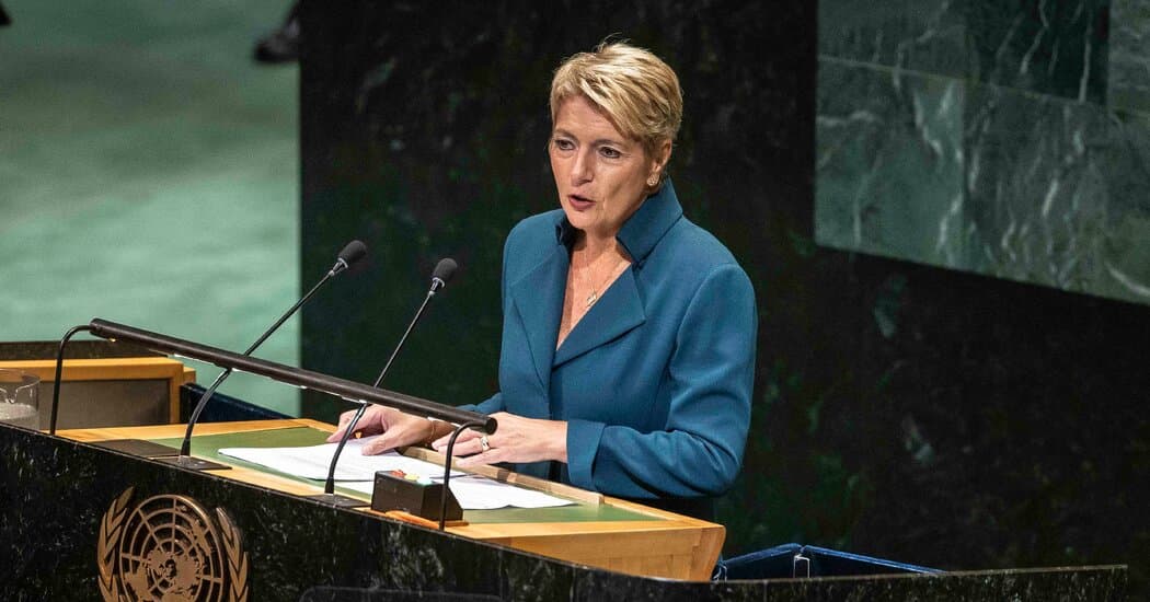 A surreal, acid-toned digital illustration showing a giant, golden Swiss watch with its gears exposed, being crushed by a massive orange wrecking ball. In the background, the snow-capped Alps are draped in oversized, red-white-and-blue neckties. The sky is a chaotic swirl of stock market tickers and melting chocolate bars. Dark satirical style, high contrast, cinematic lighting.