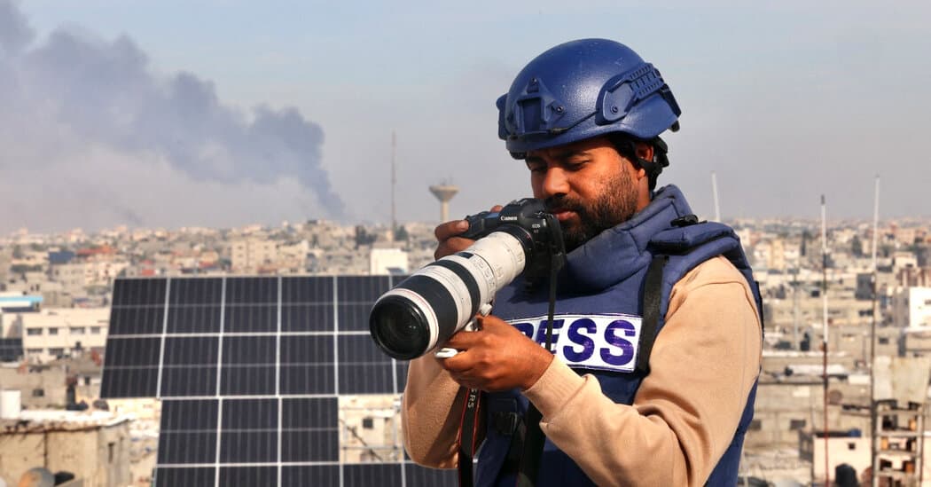 A wide, desaturated shot of a ruined urban landscape in Gaza, featuring a charred 'PRESS' helmet lying next to a mangled, high-tech consumer drone in the grey dust. In the background, the silhouette of a large military drone hovers ominously in a smog-filled sky, cinematic lighting, gritty textures.