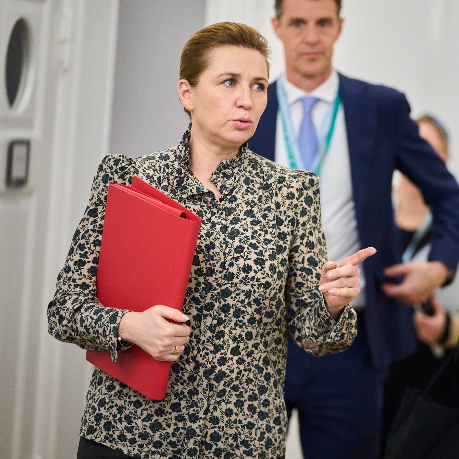 A satirical political cartoon showing a giant, bloated Uncle Sam figure trying to shove a US flag into a tiny, melting ice cube labeled 'Greenland', while a small, neatly dressed Danish bureaucrat shakes a finger at him from across a puddle of water, in a cynical, dark oil painting style.