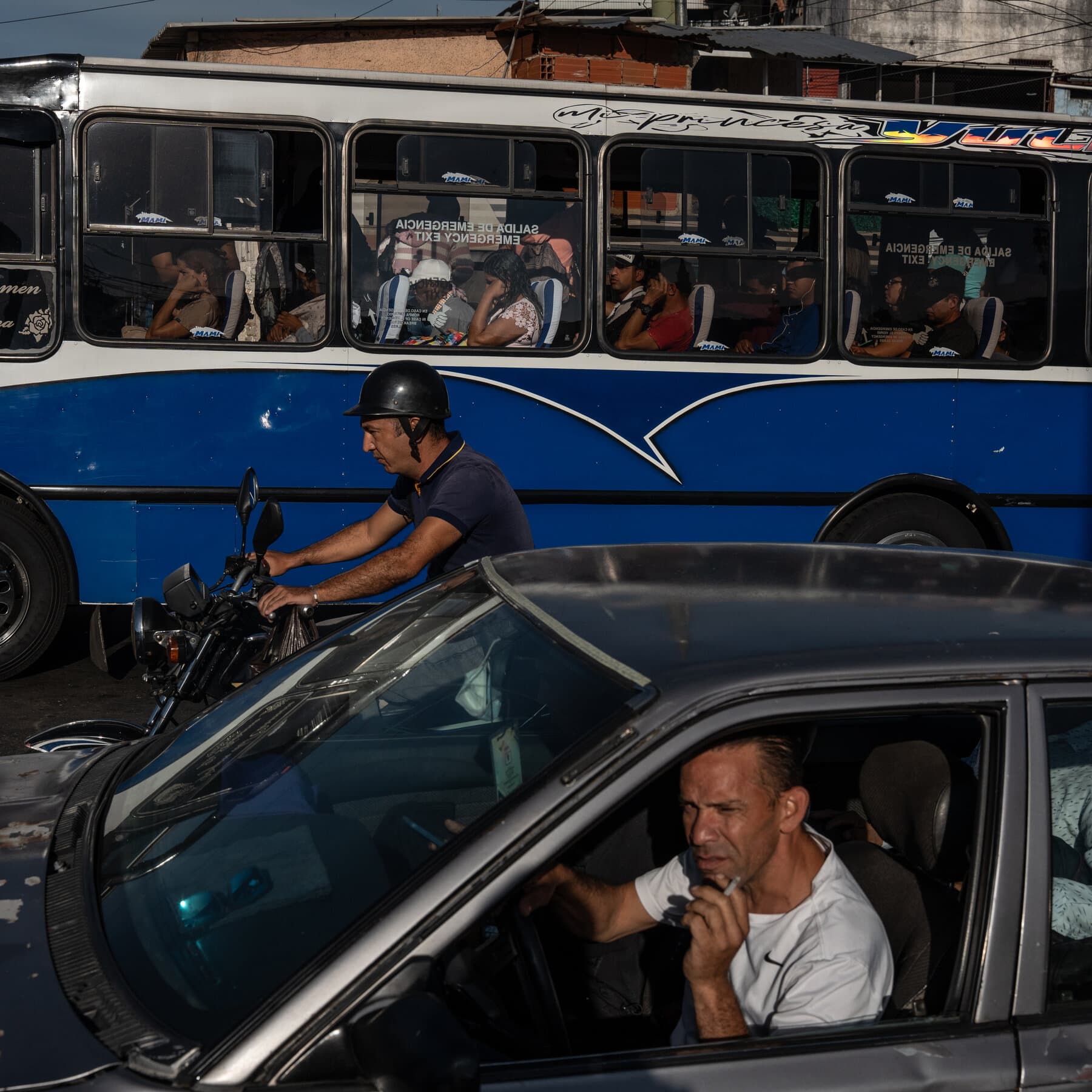 A gritty, high-contrast comic book style illustration. In the center, a shiny, golden shopping bag sits on the cold concrete floor of a dark prison cell. Inside the bag, stacks of money are glowing. Outside the cell bars, a shadowy figure in a military uniform stands guard, holding a baton. The lighting is harsh and dramatic, emphasizing the contrast between the wealth and the cage.