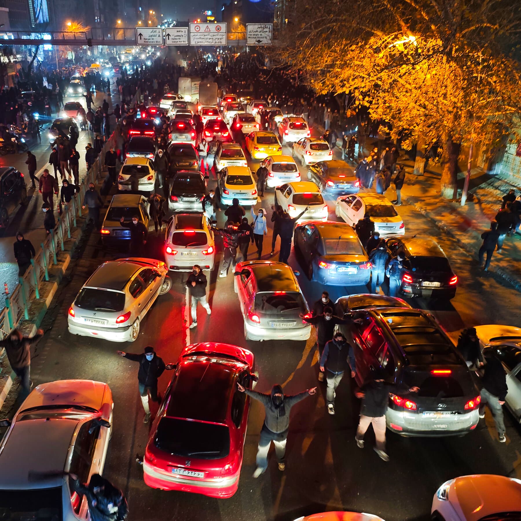 A gritty, noir-style illustration of a giant, rusted metal ear hanging from a telephone pole in a dark, empty city street. Wires connect the ear to smartphone screens glowing on the ground. Muted colors, dark blues and greys, high contrast.