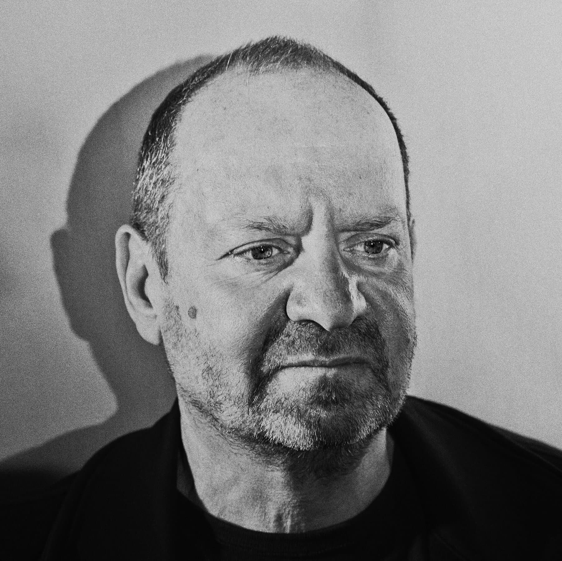 A high-angle, cinematic shot of a massive, leather-bound law book titled 'INTERNATIONAL LAW' being used to prop up a heavy, rusted iron gate that is failing to stop a flood of dark, thick ink. The setting is a cold, grey judicial hall with cracked marble floors. The lighting is harsh and cynical.