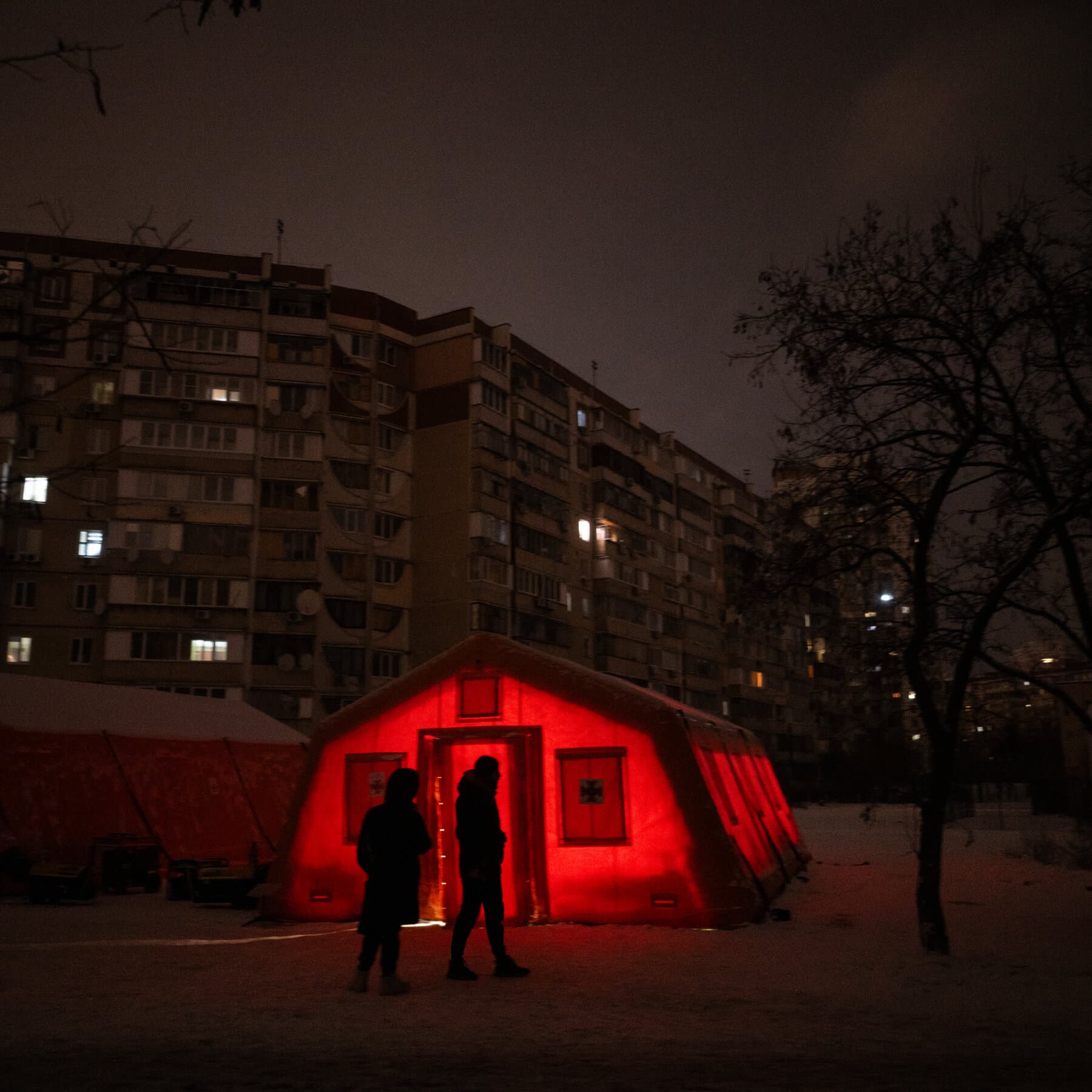 A gritty, hyper-realistic black and white illustration of a coal mine entrance in winter. The scene is bleak and industrial. Snow is falling heavily on rusted machinery and piles of coal. In the background, faint smoke rises from a damaged power plant structure, blending with the grey winter sky. No people are visible, only the abandoned hard hats and tools left in the snow, symbolizing the loss of the workers. The atmosphere should feel cold, silent, and abandoned.