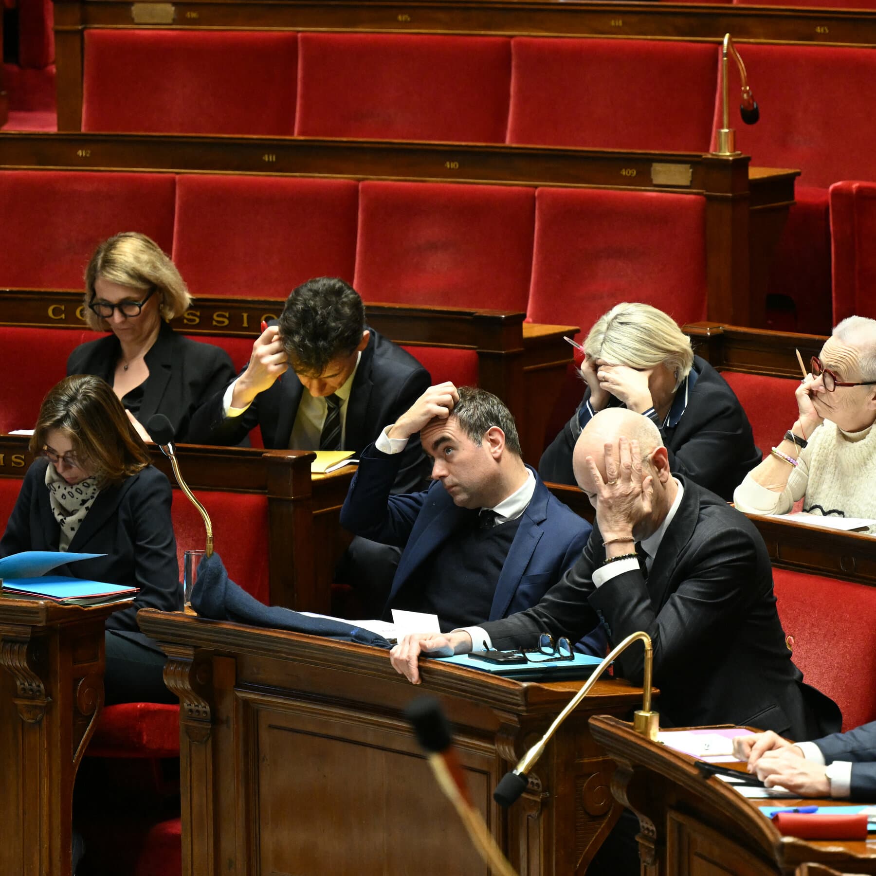A single, slightly crumpled budget document resting on an ornate, dusty French desk in an empty, dimly lit government hall. The atmosphere is cold and cynical.