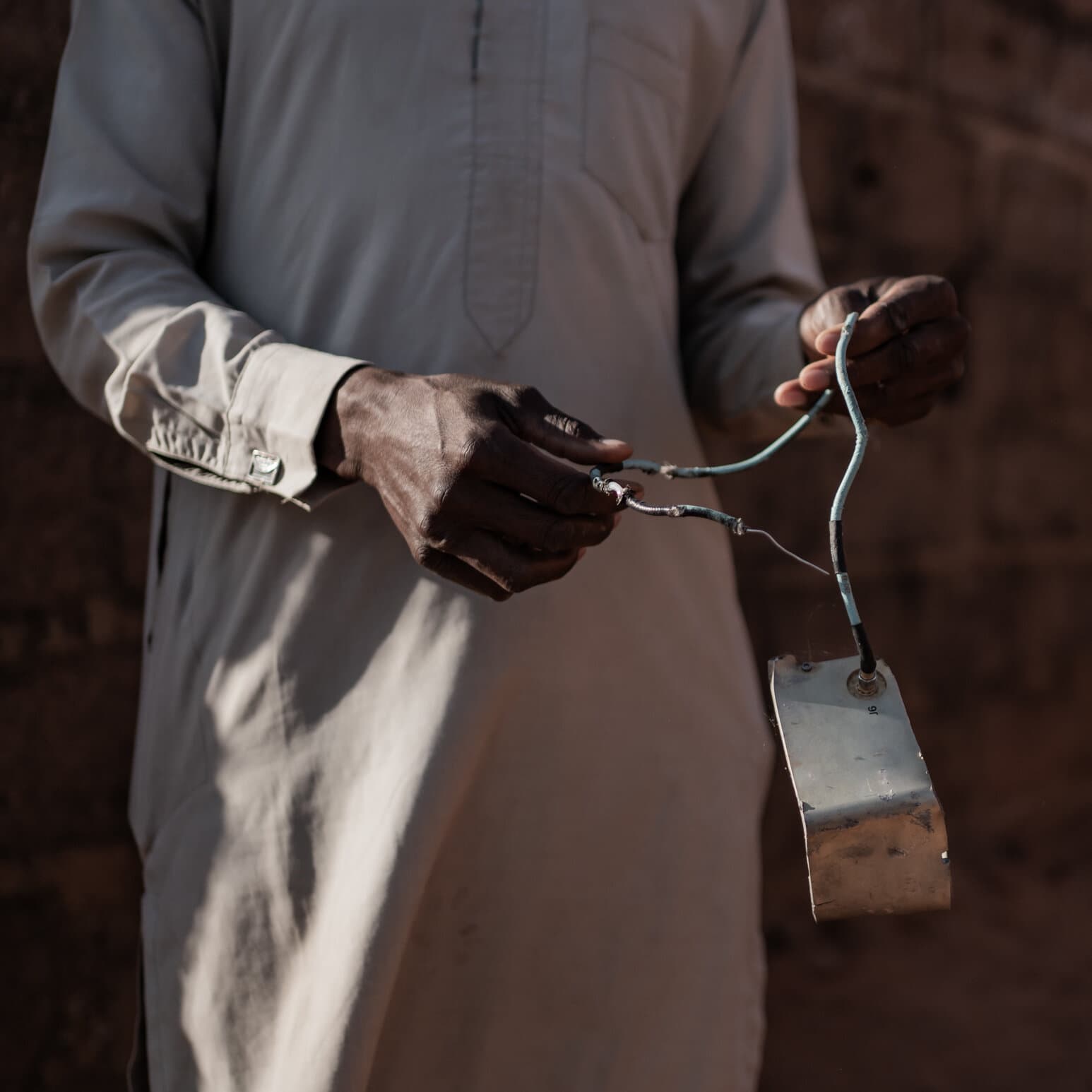 A gritty, noir-style illustration of a faceless lobbyist in a dark suit exchanging a briefcase filled with papers for a map of Nigeria. The background is a blurry, gray Washington DC skyline. The mood is cynical and cold. High contrast, comic book ink style.