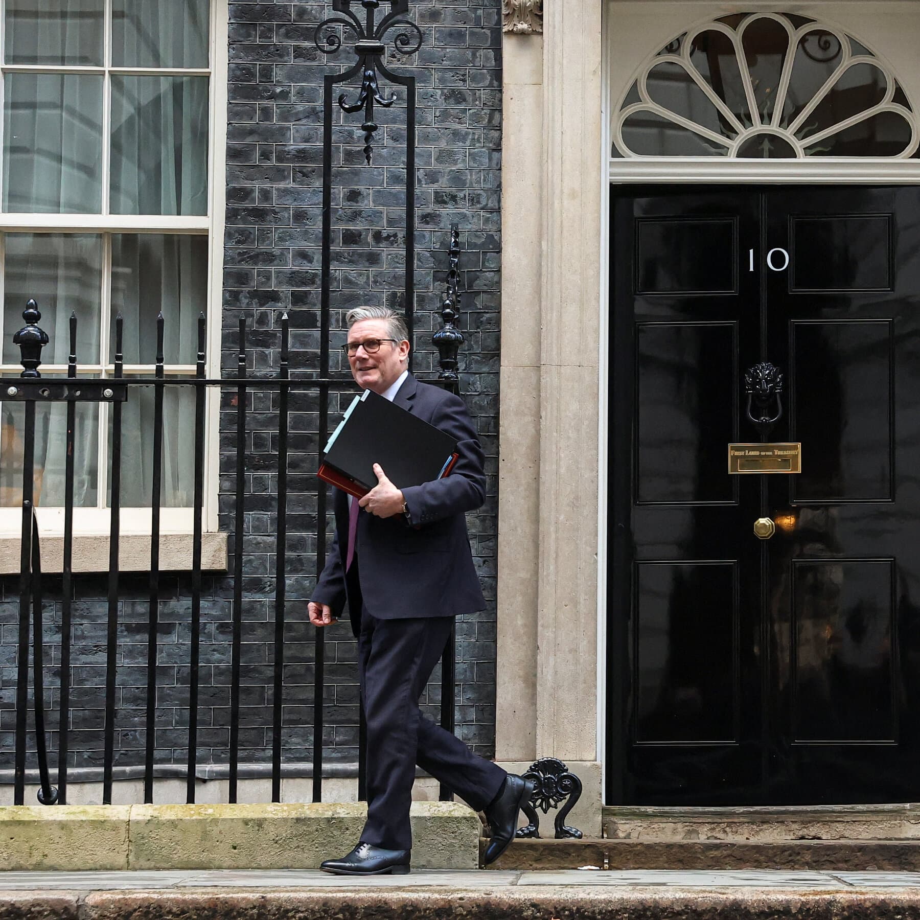 A gritty, high-contrast black and white illustration of a generic politician in a suit standing in front of a crumbling British flag, looking down at a shredded document on the floor, ominous shadows, cynical street art style.
