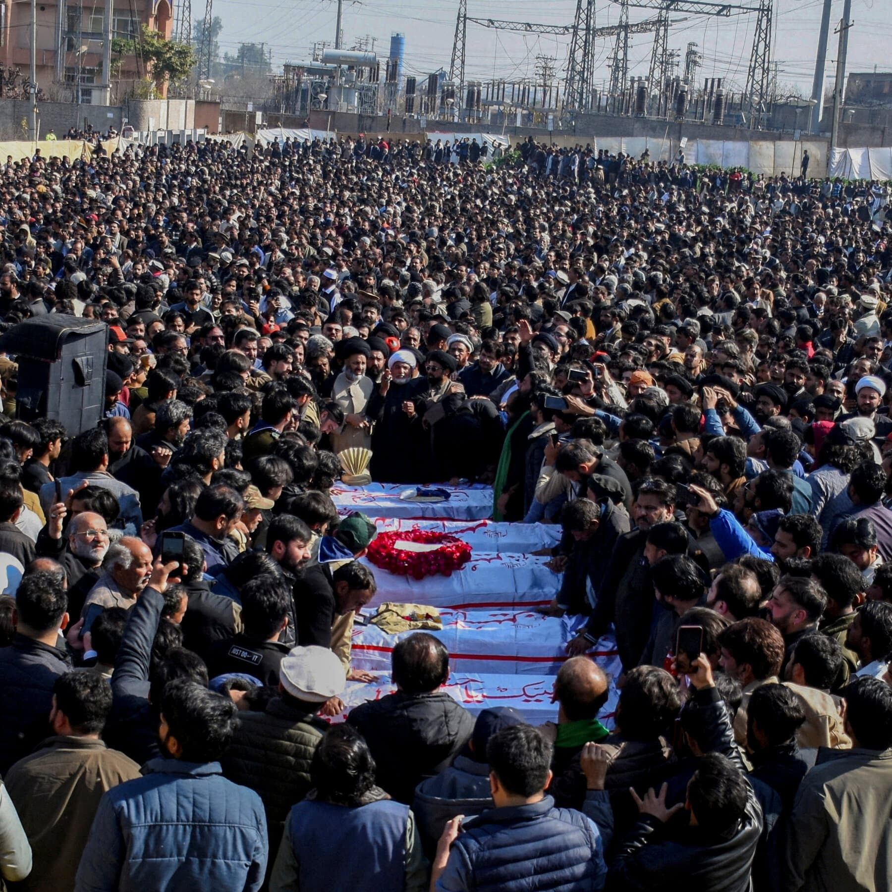 A highly stylized, gritty illustration of a shattered concrete wall with a faded, torn poster of a politician smiling on it. The background is a dusty, chaotic street scene in muted greys and browns, symbolizing the contrast between official promises and broken reality. Digital art style, dark and cynical atmosphere.