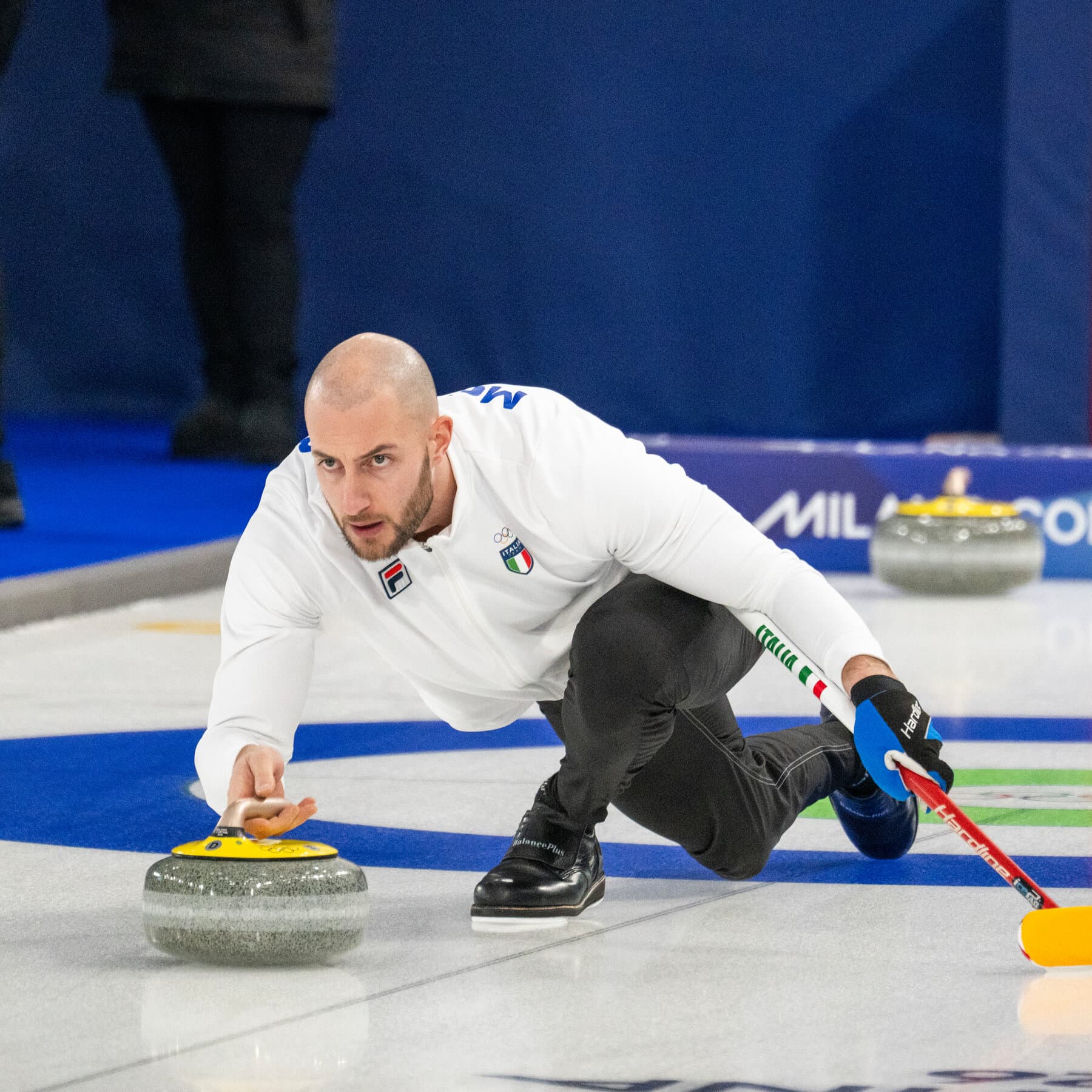 A gritty, cynical editorial illustration in a rough hand-drawn style. Depict an Italian police officer in full uniform, but instead of a gun holster, he is wearing ice skates and holding ski poles. He looks bored and is leaning against a crumbling Roman column. In the background, a chaotic mix of military generals and politicians are arguing over a gold medal like children fighting over a toy. The color palette should be muted blues, greys, and dirty gold, emphasizing the absurdity and waste of the situation.