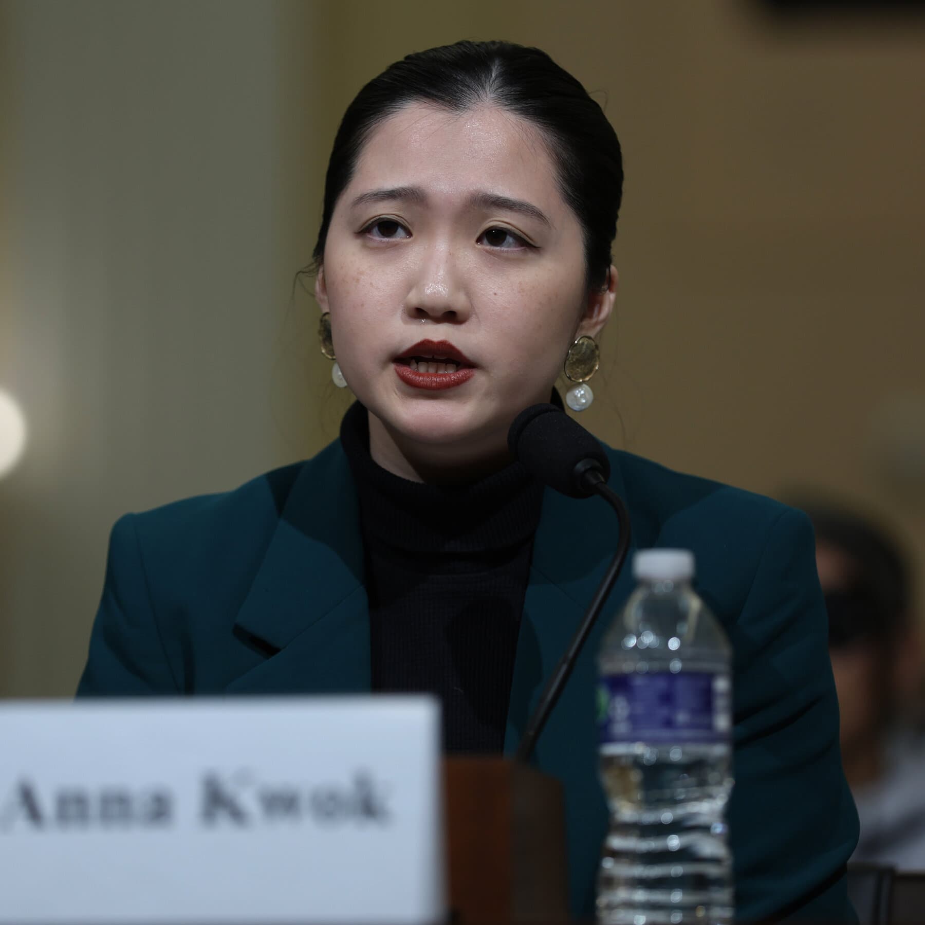 A single, empty wooden chair sitting in the center of a vast, dark, concrete room, illuminated by a single harsh spotlight, representing the isolation and absurdity of the judgment, high contrast, noir style.