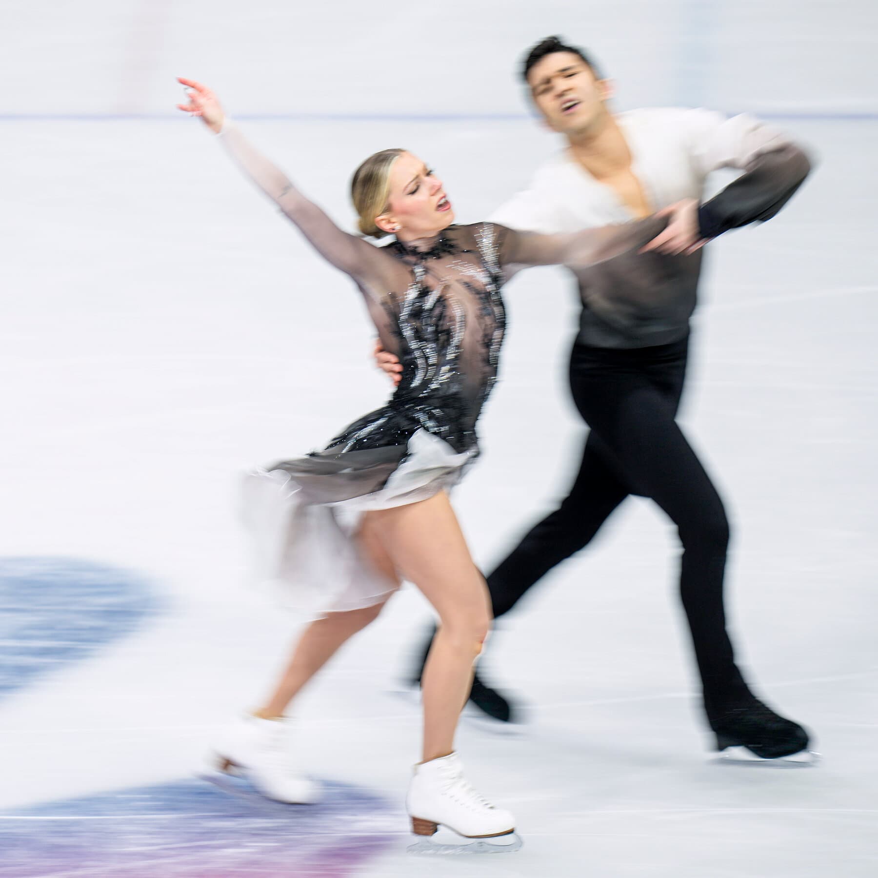 A gritty, cynical editorial cartoon style image. In the center, a figure skater in a sparkling outfit looks terrified on the ice. Instead of ice skates, they are wearing heavy metal shackles connected to a ball and chain. Behind them, shadowy figures in business suits are holding out greedy hands. The ice surface is cracked, revealing dollar bills underneath. The lighting is dim and dramatic, emphasizing the hopelessness of the situation.