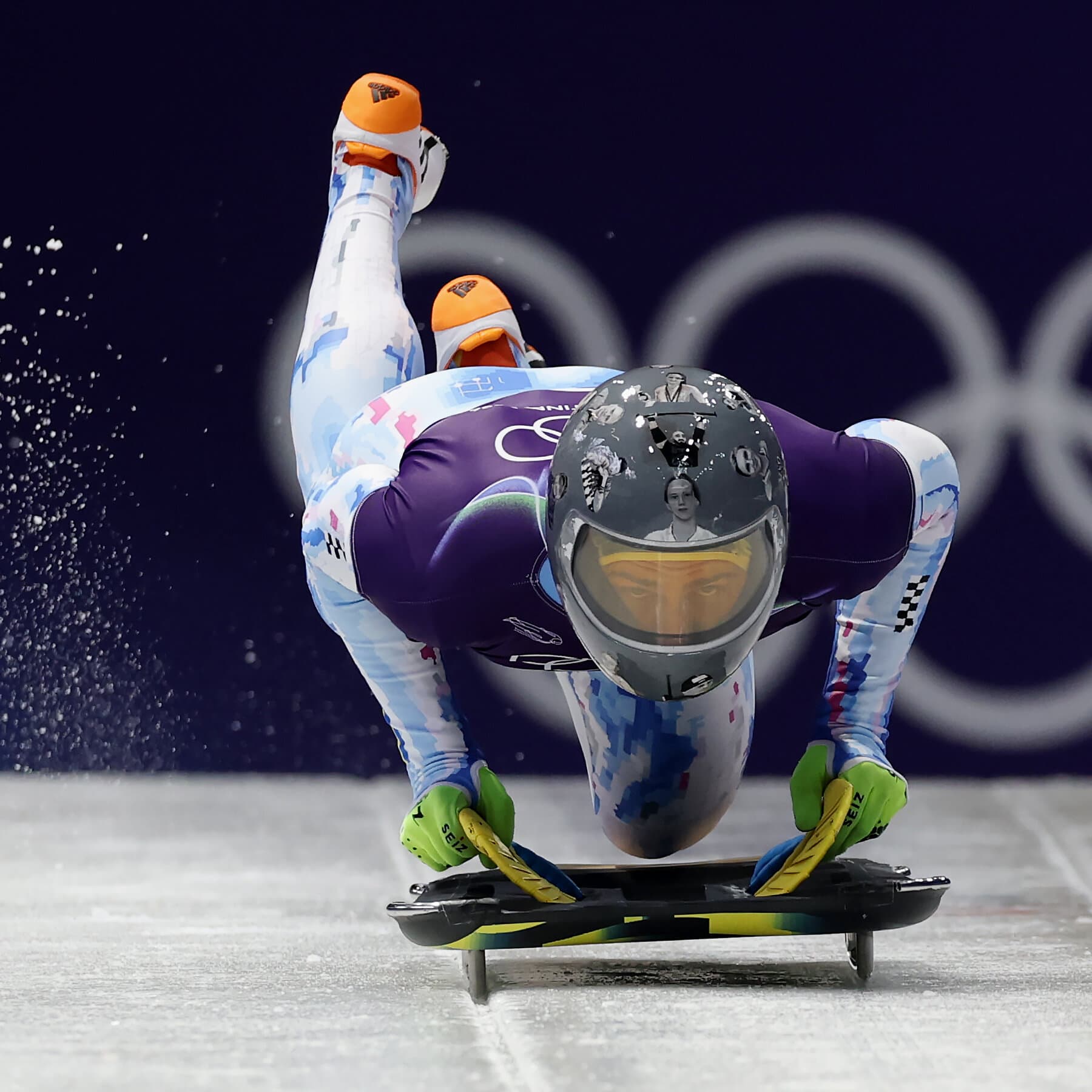 A hyper-realistic, cynical editorial illustration showing a pristine, white Olympic skeleton helmet sitting on a podium. The helmet is wrapped in red bureaucratic tape that says 'CENSORED' in bold letters. In the reflection of the helmet's visor, you can see faint, ghostly faces of people. The background is a blurry, sterile blue boardroom with faceless figures in suits turning their backs on the helmet. The lighting is cold and clinical.