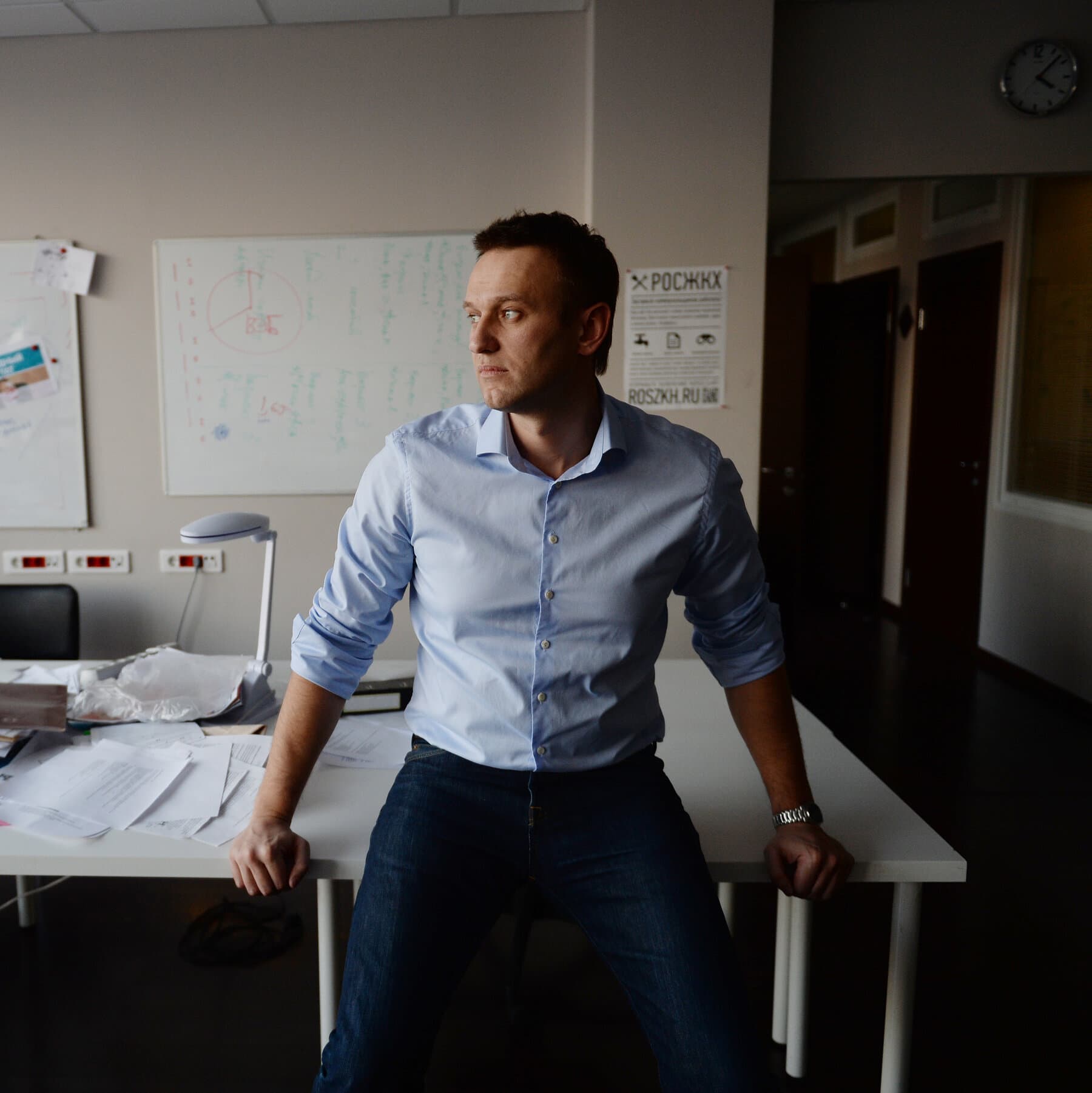 A moody, noir-style illustration of a bright poisonous dart frog sitting on top of a stack of grim, stamped government files in a sterile, cold interrogation room.