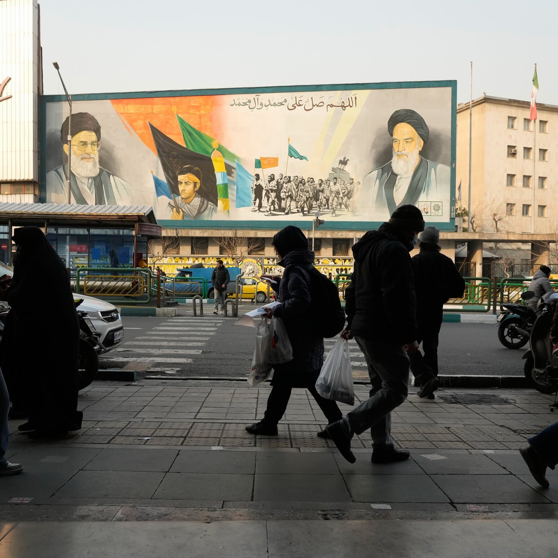 A moody, high-contrast black and white street photography style image of a lone figure sitting on a curb in Tehran, head in hands, surrounded by blurred passing crowds, heavy shadows, gritty texture, atmosphere of despair and isolation.