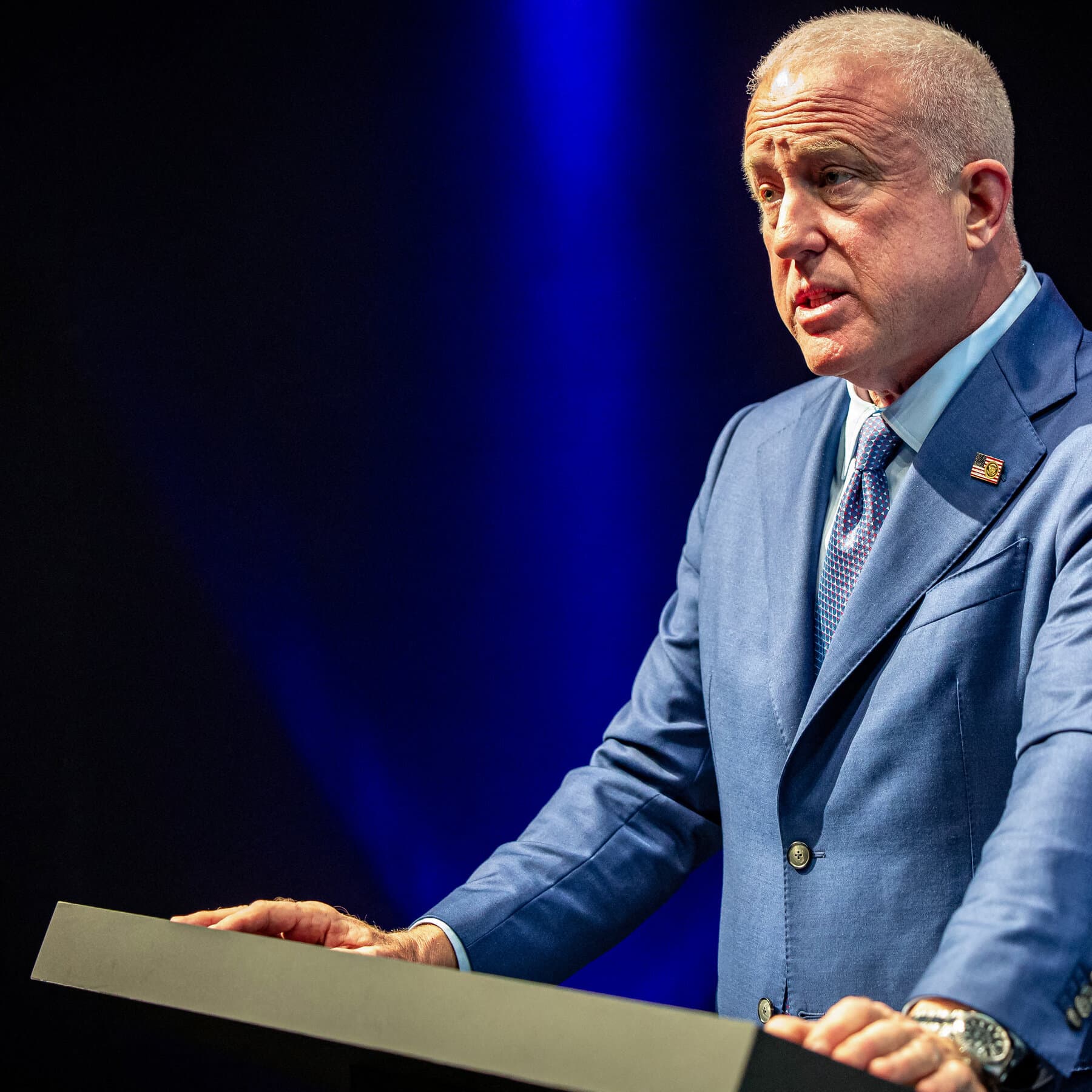 A hyper-realistic, cynical editorial illustration showing a classic, ornate European diplomatic meeting room. On one side of a long polished table sits a stiff, exasperated Belgian official in a dark suit, looking shocked. On the other side, an empty chair with an American flag draped over it, or a figure looking dismissive. In the center of the table, a teacup has been spilled, staining a document. The lighting is moody and dramatic, emphasizing the tension and the crumbling of old-world decorum. No text.