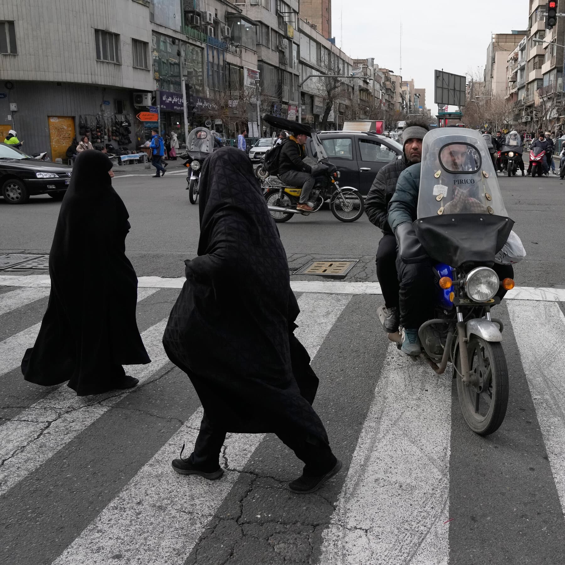 A minimalist, high-contrast illustration in a cynical editorial style. A large, menacing stone wall is cracking down the middle. In the foreground, silhouettes of ordinary people stand quietly holding candles. The light from the candles casts long, giant shadows against the cracking wall. The shadows look like giants, dwarfing the wall itself. The color palette is dark grey, black, and a piercing amber yellow for the candlelight. No text, purely symbolic of grief overpowering suppression.