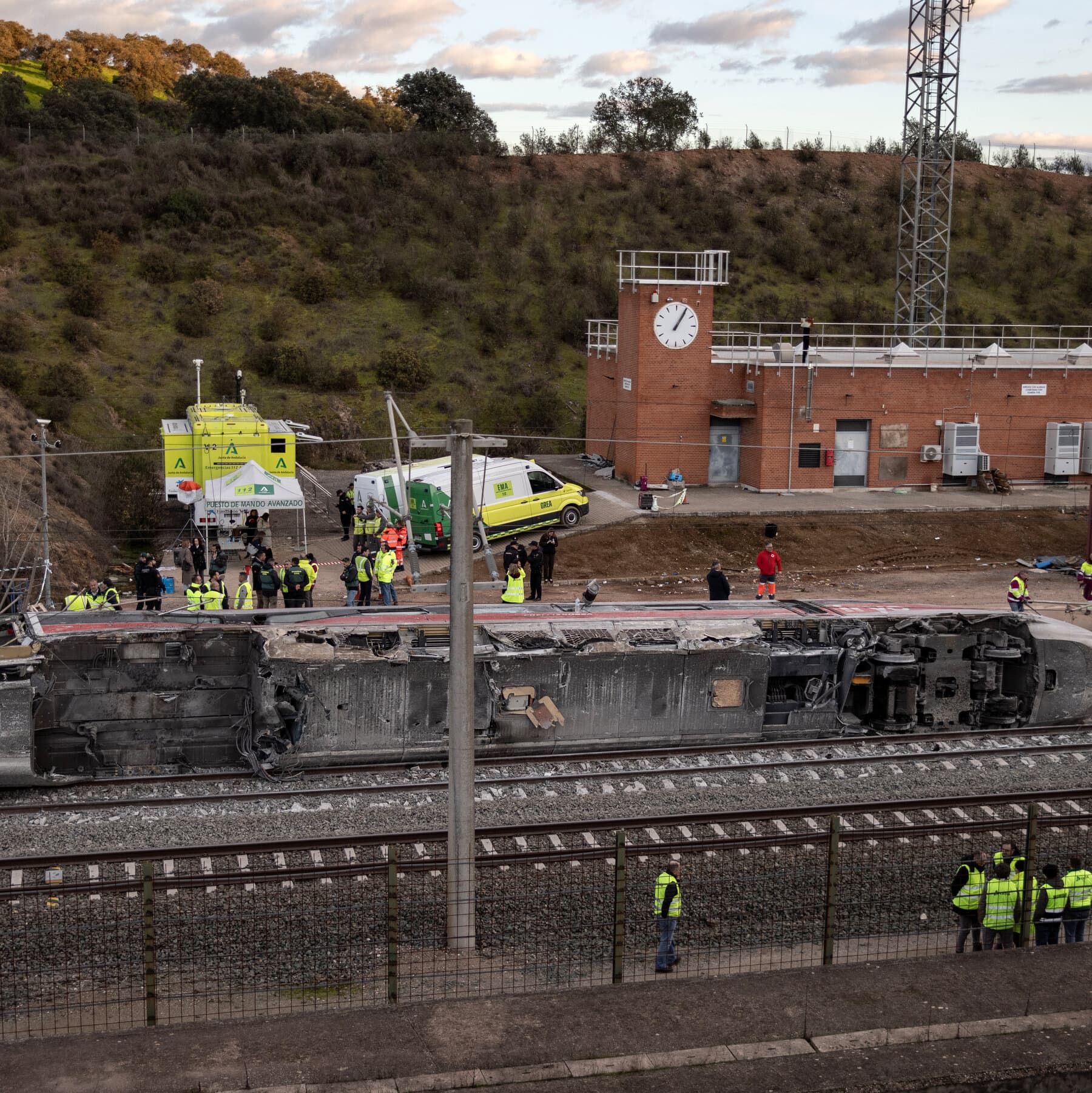 A photo of a giant, translucent hand descending from the clouds holding a red pen and crossing out a real-life train on a set of tracks in the Spanish countryside, news photography style.